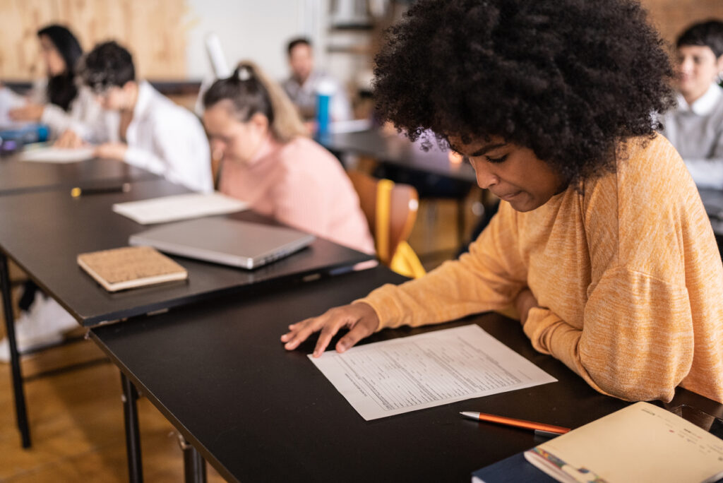 Students focused on completing a written exam in a classroom setting.